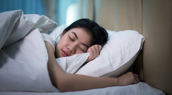 Women sleeping on side in bed, Better Sleep Council