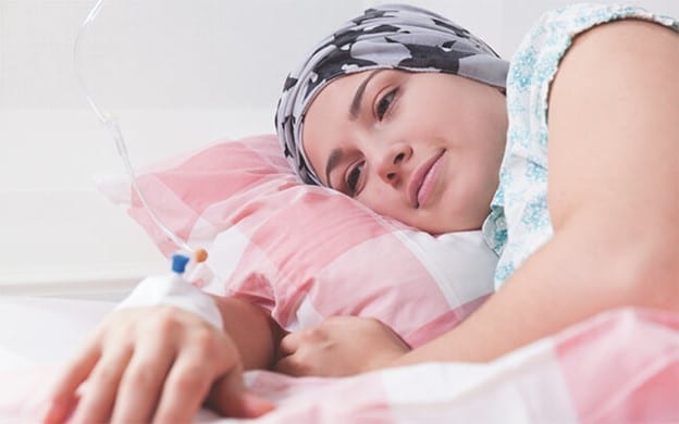 female cancer patient resting on pink pillow