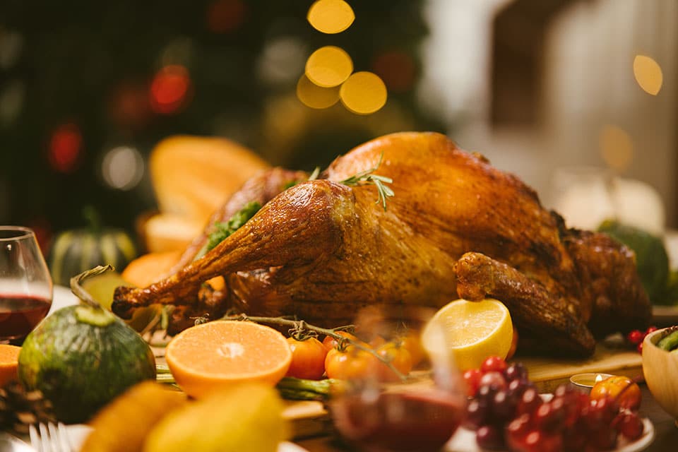 Roast Turkey with herb and fruit garnishments on a festive table setting