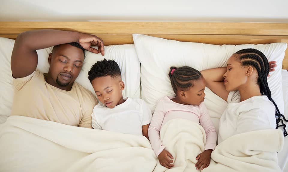A family that naps together stays together. Shot of a family sleeping in bed at home
