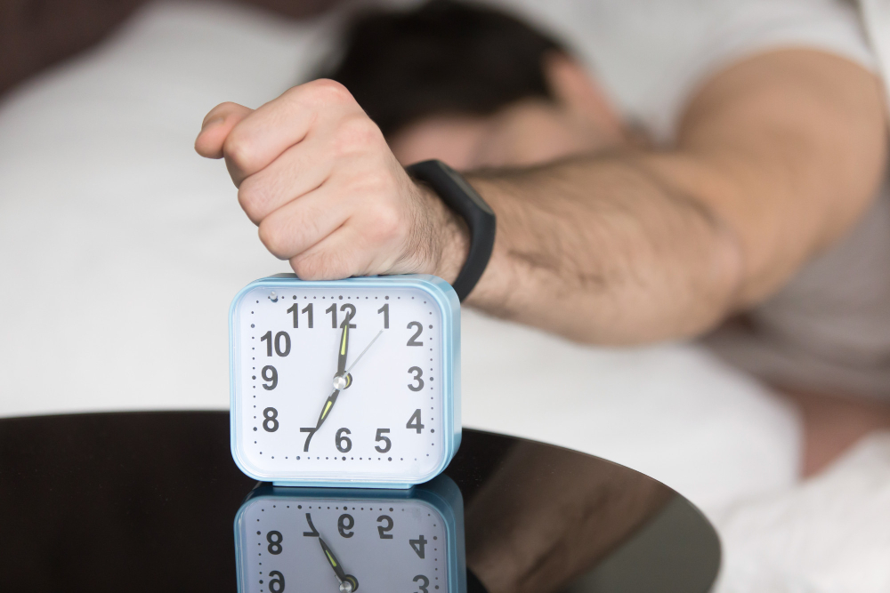 Man hitting alarm, showing Psychology of the Snooze Button